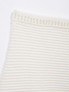 Détail de la maille blanche avec garniture de perles élégantes sur le bord supérieur
