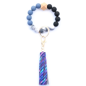 Detail of beaded keychain with purple fringe, marble beads and wooden star accessory