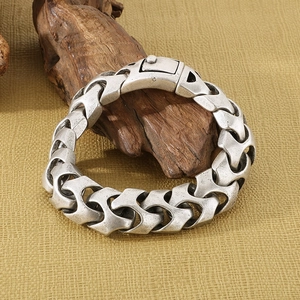 Gros plan du bracelet chaîne en argent antique avec un fermoir carré robuste et industriel