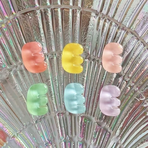 Close-up of colorful translucent resin bean accessories on an iridescent shell surface