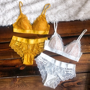 Détail à plat d'ensembles de lingerie en dentelle gingembre et blanc sur textures
