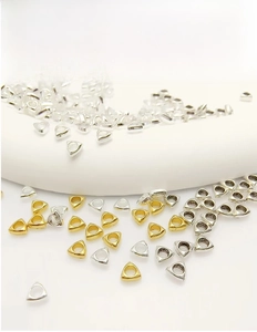 Macro shot of triangular metallic spacer beads in gold and silver plating for DIY jewelry