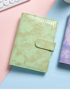 Close-up of mint green crocodile pattern PU leather binder notebook with snap button closure