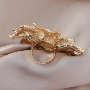 Chic gold sunflower-inspired textured alloy open ring on elegant pink silk fabric