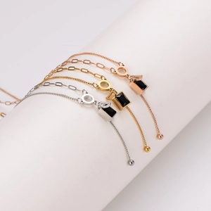 Elegant gold, silver, and rose gold link bracelets with black acrylic charms and tassels