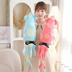 Adult holding two large colorful squid plush pillows with polka dots in a cozy room setting