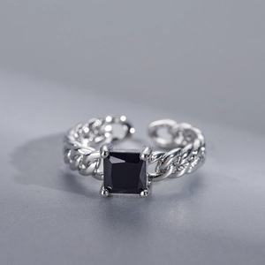 Detail of silver chain ring with a square black gemstone in a minimalist open design