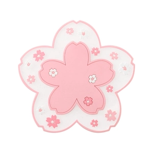 Pink sakura shaped silicone placemat with white floral accents on a clean white background