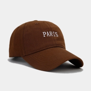 Close-up of white PARIS embroidery on a vintage dark brown twill cotton baseball cap