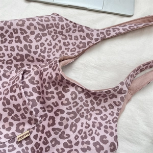 Detail of leopard print suede tote bag featuring wide shoulder strap and fabric texture
