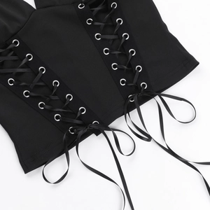 Détail du haut dos nu noir avec œillets métalliques et laçage en ruban de satin