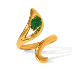 Macro detail of bypass gold ring with a sparkling pear-cut green gemstone setting