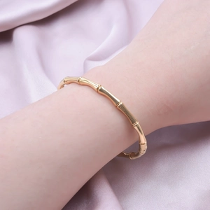 Adjustable golden bamboo joint design stainless steel bracelet worn on a woman's wrist