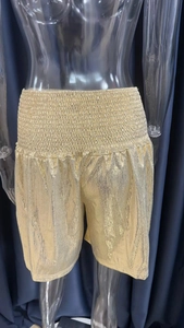 Detailed view of elastic waistband and metallic gold fabric on casual loose shorts
