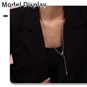 Detail of silver snake chain Y-necklace with elegant knot pendant on model