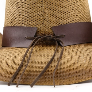 Close-up of khaki woven straw cowboy hat with dark brown faux leather bow band detail