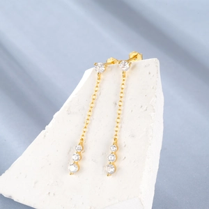 Close-up of S925 sterling silver long chain earrings with zircons on textured stone