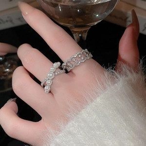 Detail of elegant two-piece ring set with pearls and zircons on a model's hand