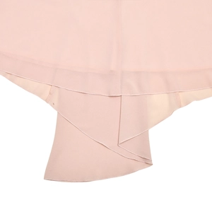 Détail d'une robe en mousseline plissée rose clair avec ourlet irrégulier et texture