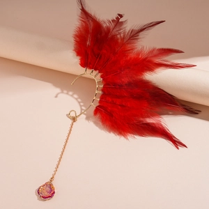 Λεπτομέρεια από χρυσό σκουλαρίκι ear cuff με κόκκινα φτερά και στρογγυλό μενταγιόν