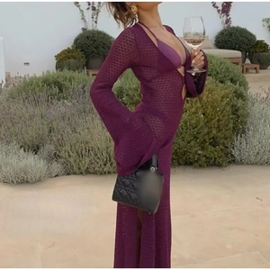 Detalle del vestido de punto calado púrpura con escote en V profundo para la playa