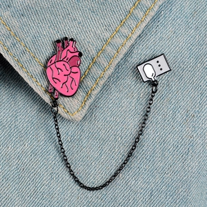Pink heart and computer pins linked by chain on denim jacket collar, creative metal brooch