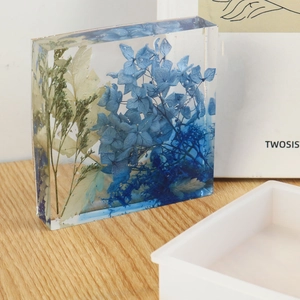 Detail of square silicone mold and a transparent resin block with blue hydrangea