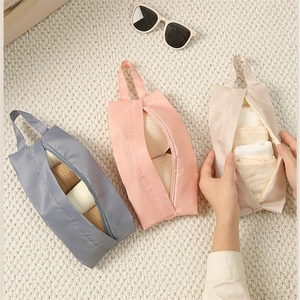Portable travel underwear organizer bags in grey, pink, and beige with top handles