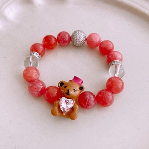 Vue détaillée du bracelet perlé avec pendentif ours brun tenant un cœur rose