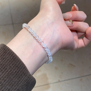 Macro shot of white translucent quartz bead bracelet worn on wrist with gentle gloss