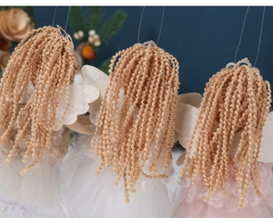Detail of wool-like hair and tulle skirts on Christmas angel tree ornaments