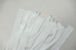 Close-up of white fabric straps and pleated texture details on a stylish bodycon dress