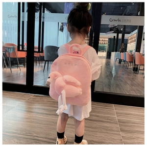 Detail view of pink plush toddler backpack featuring a 3D flamingo and soft flamingo wings