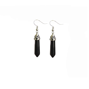 Close-up of black hexagonal crystal pillar earrings with silver patterned metal caps