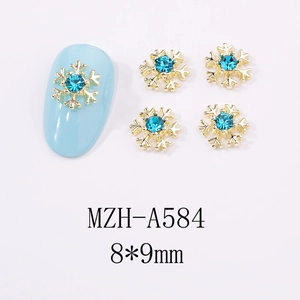 Détail de bijoux d'ongles flocon dorés 8x9mm avec strass bleu clair au centre