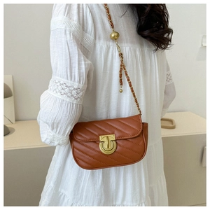 Detail of caramel chevron quilted crossbody bag with gold chain and ball adjustment