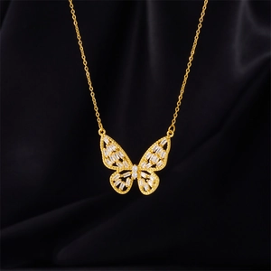 Elegant gold butterfly pendant necklace with white zircon crystals on black silk background