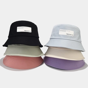 Detail of multi-color cotton bucket hats showcasing texture and decorative woven labels