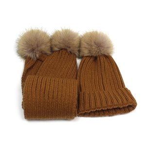 Detail view of the thick knit texture and fluffy faux fur pom-poms on the winter scarf set