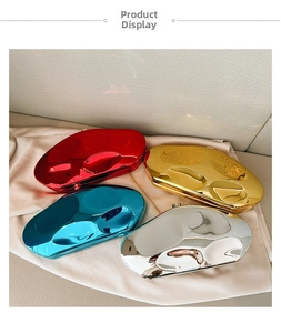 Polished pebble-shaped clutch bags in red, gold, blue, and silver on silk fabric