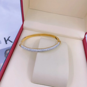 Close-up of gold titanium bracelet with shimmering pave-set zircon detail on leather pad