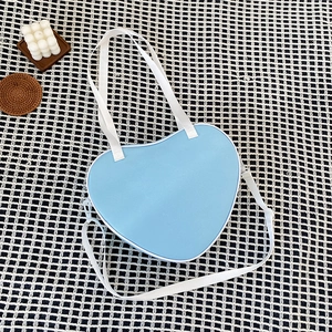 Light blue heart-shaped ita bag with white handles on a black and white plaid background