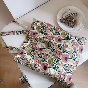 Vintage floral canvas tote bag with pink flower patterns and decorative woven label