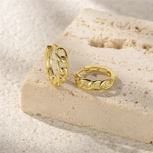 Detail of gold chain link hoop earrings displayed on a natural beige textured stone