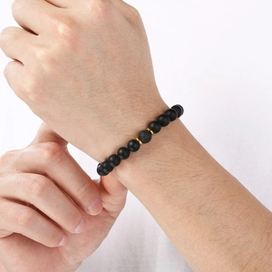 Detail of 8mm black matte agate and volcanic lava stone beaded bracelet on a wrist