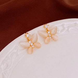 Detailed macro view of butterfly earrings with cat eye stones and sparkling zircons