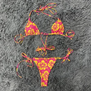 Detailansicht des rosa Blumen-Bikinis mit gelben Hibiskus-Prints und seitlichen Bindebändern