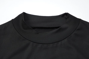 Gros plan détaillé d'une robe en maille noire montrant le col haut et le tissu côtelé