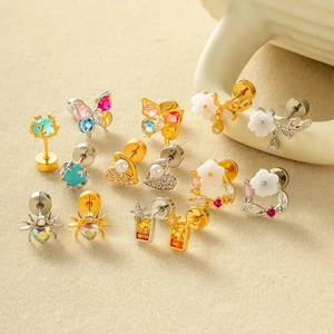 Various colorful zircon butterfly heart and spider steel stud earrings on ceramic tray