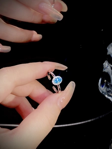 Macro shot of silver ring featuring an oval aquamarine gemstone and diamond halo detail